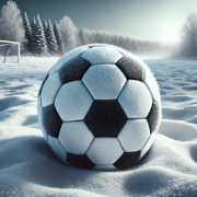 Ballon de football sur un terrain enneigé avec un paysage hivernal en arrière-plan